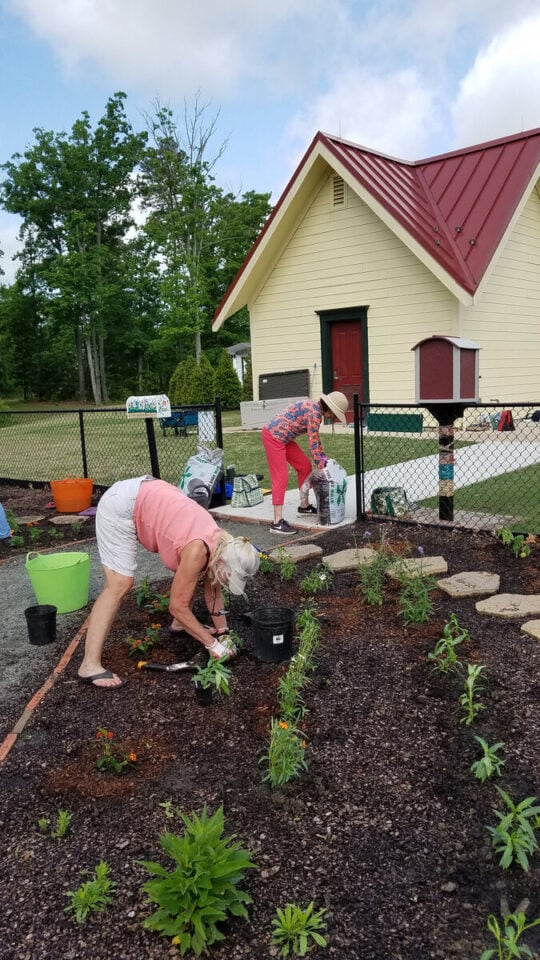 Volunteers planting flowers beside the Short Pump Park recreation building